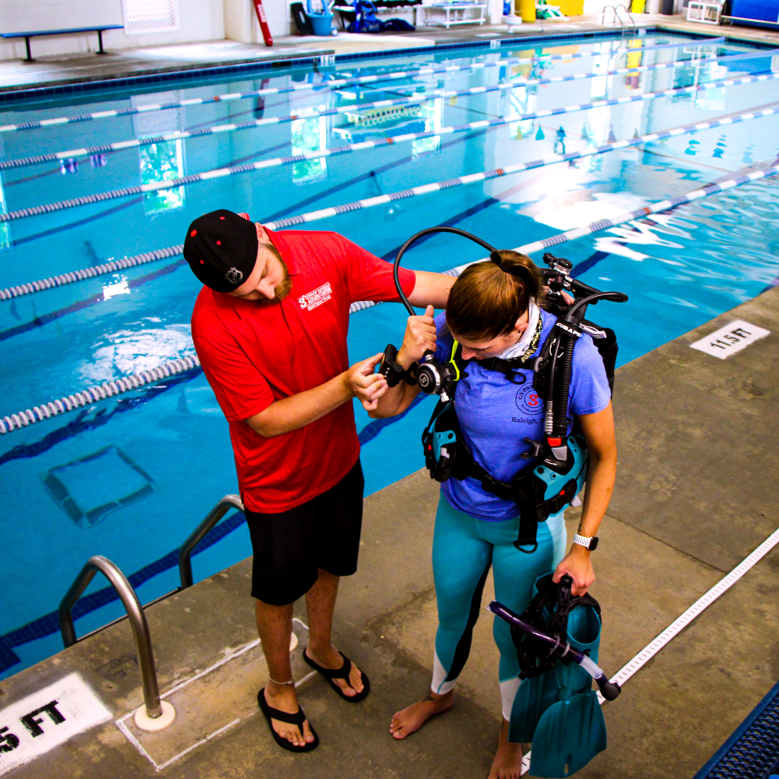 A dive instructor reminding a student to check their computer