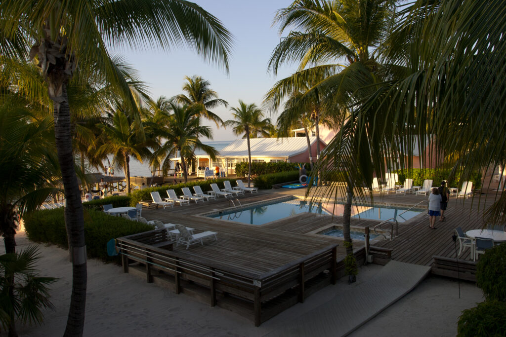 The resort houses a pool with plenty of seating and a beautiful backdrop of the ocean.