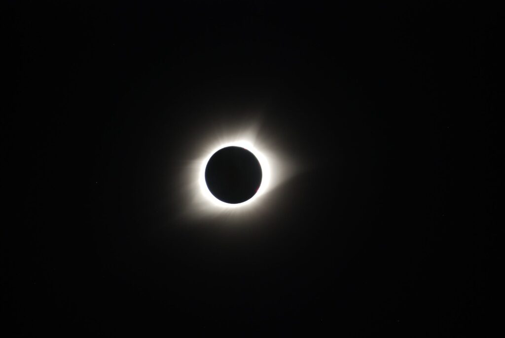 A black sky surrounds a small glowing orb that is a solar eclipse.